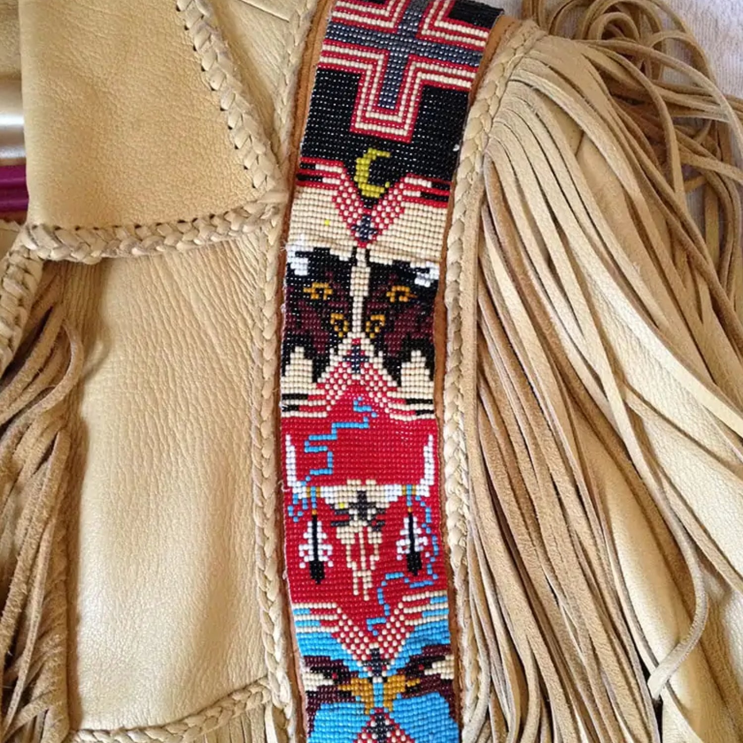 Side profile showing the beige leather fringe jacket with beaded detailing